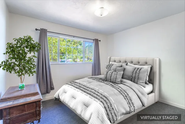 a large bed sitting in a bedroom next to a window