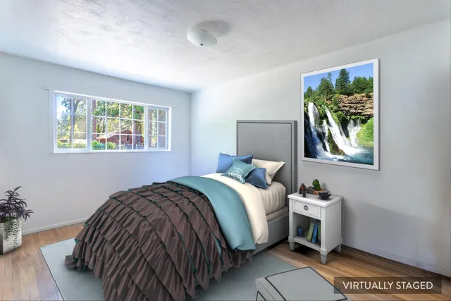 a bedroom with a bed and a painting on the wall