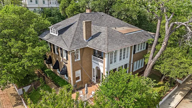 an aerial view of house with yard and trees in the background