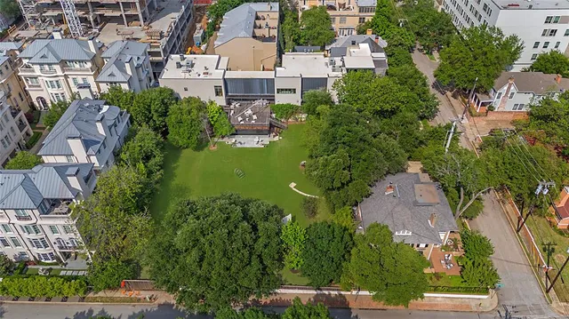 an aerial view of residential building with outdoor space and trees all around