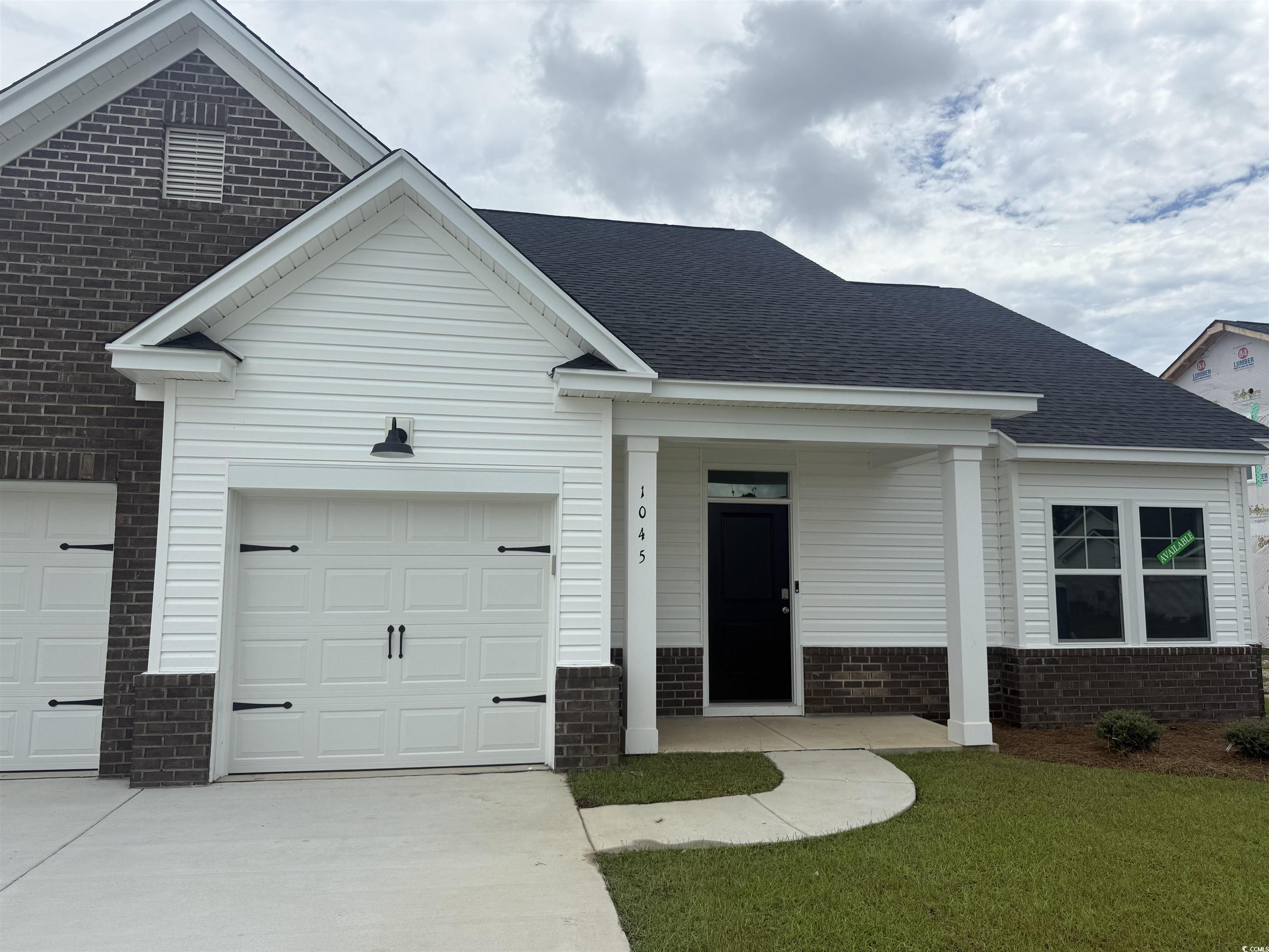 1045 Jase Drive Longs, SC 29568 - Photo 2 of 33 Ranch-style house featuring driveway, brick siding, an attached garage, a front lawn, and roof with shingles