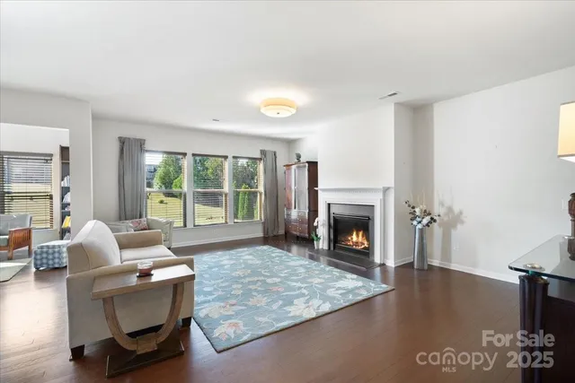 a living room with furniture large window and fireplace
