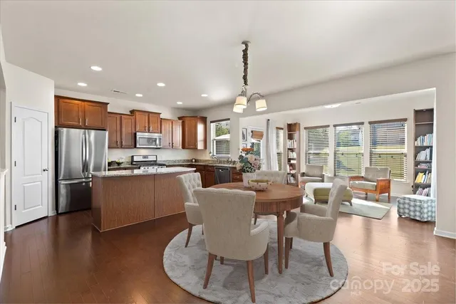 a view of kitchen with refrigerator a stove and wooden floor