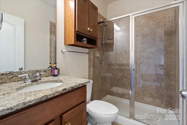 a bathroom with a granite countertop sink a mirror and a shower