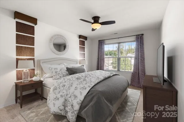 a bedroom with a large bed and a flat tv screen on dresser