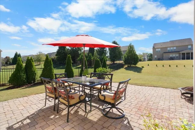 a view of a patio with a table and chairs under an umbrella