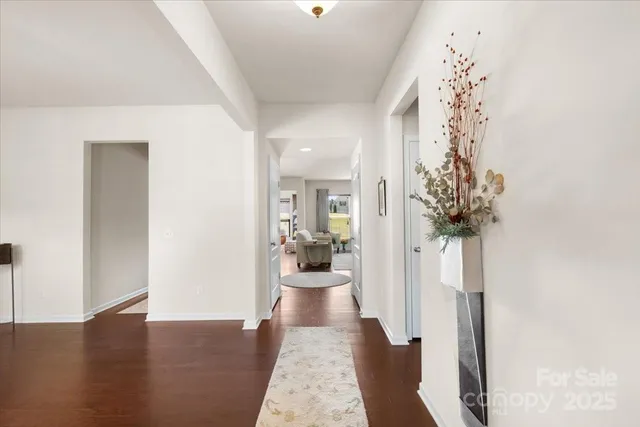 a hallway with a dining room and chandelier