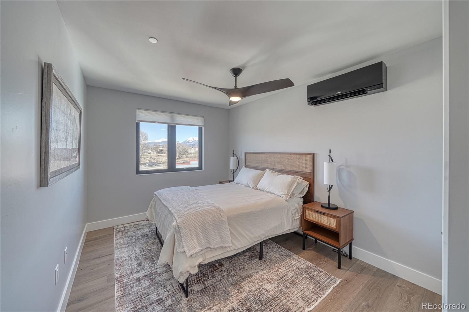 136 Old Stage Road, Unit 1E Salida, CO 81201 - Photo 23 of 26 a bedroom with a bed a chandelier and a window