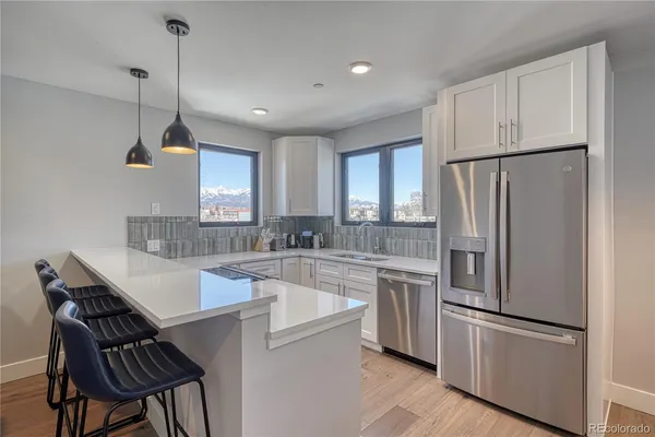 a kitchen with a sink a stove cabinets and wooden floor