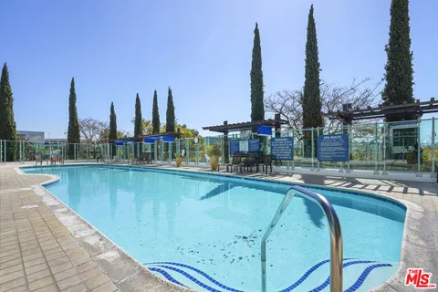 a view of a building with a swimming pool and sitting area