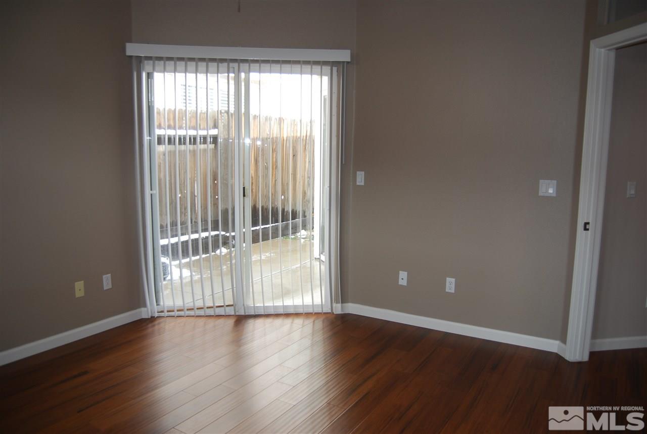 1249 Tule Drive Reno, NV 89521 - Photo 9 of 12 an empty room with wooden floor and windows