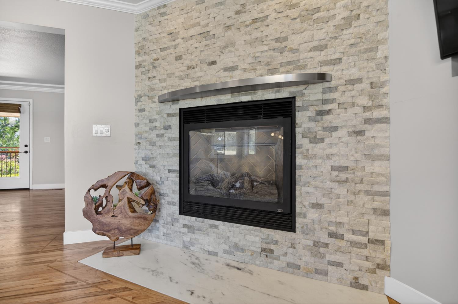 5560 Ralston Way Placerville, CA 95667 - Photo 15 of 78 Floor-to-ceiling stacked stone fireplace featuring an integrated gas fireplace and a white stone hearth