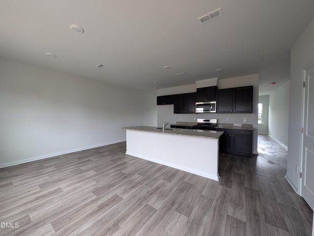 a kitchen with kitchen island a sink and a stove top oven