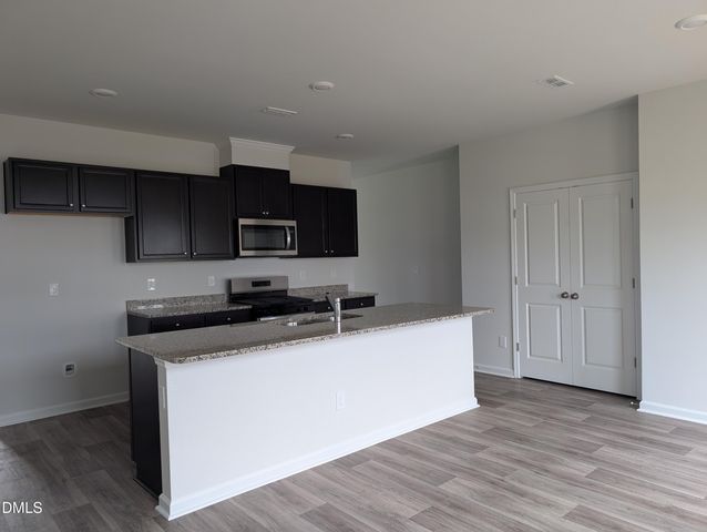 a kitchen with a sink a microwave a stove and refrigerator