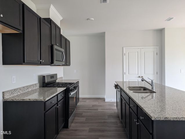 a kitchen with granite countertop a sink and cabinets