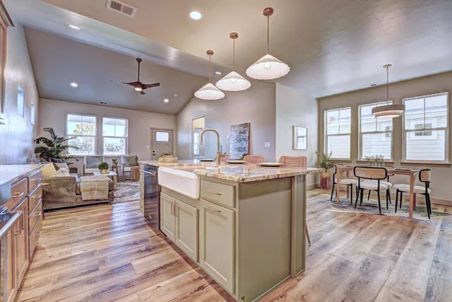 a large kitchen with lots of counter space a sink appliances and dining table