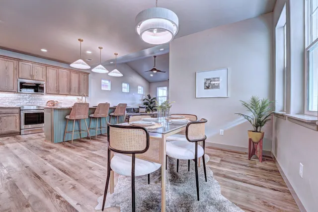a dining room with kitchen island furniture a chandelier and kitchen view