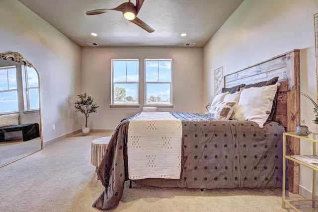 a spacious bedroom with a bed and a chandelier