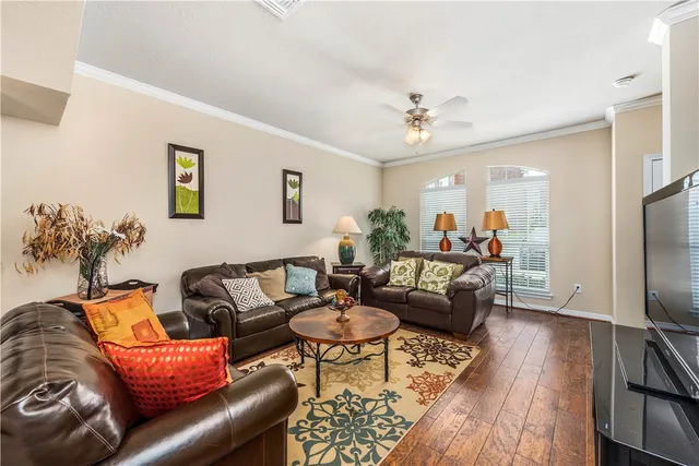 a living room with furniture a wooden floor and a flat screen tv
