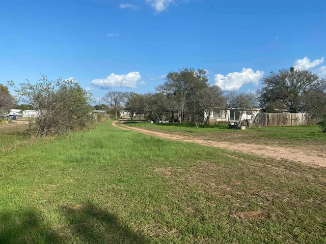 a wooden fence with some plants in the background