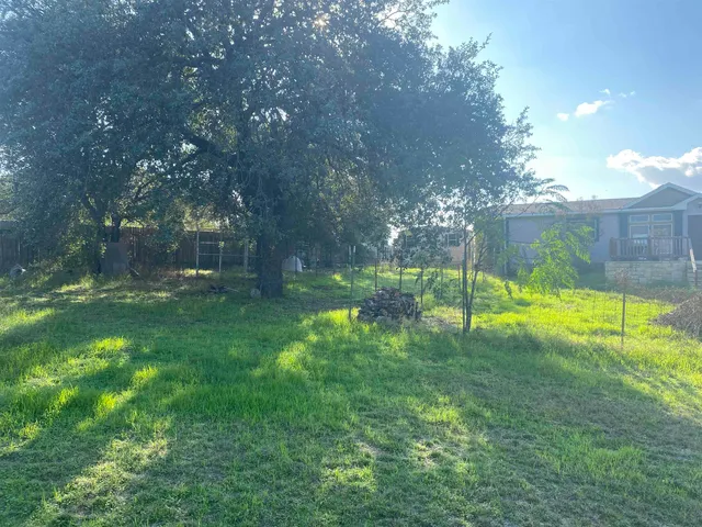 a view of a park with a house in the background