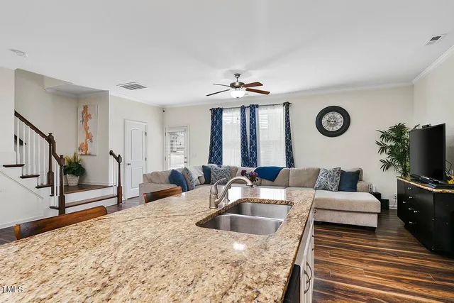 a living room with furniture a flat screen tv and a table