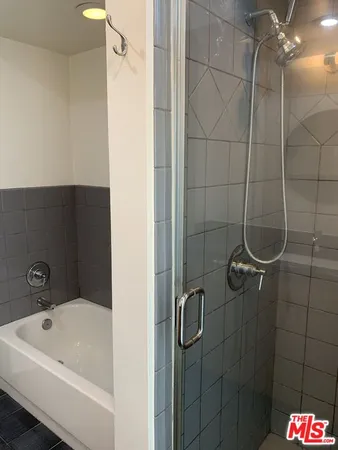 a bathroom with a granite countertop sink toilet a mirror and bathtub