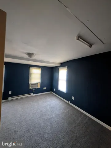 an empty room with windows and fireplace