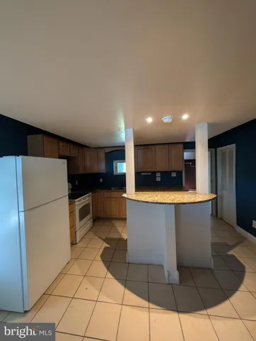 a large kitchen with stainless steel appliances a refrigerator and a cabinets