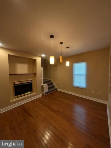 a view of an empty room with a fireplace and a window