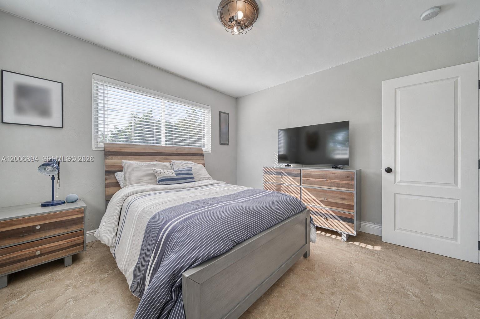 10600 Southwest 80th Court Miami, FL 33156 - Photo 15 of 51 a bedroom with a bed and a flat tv screen on wall