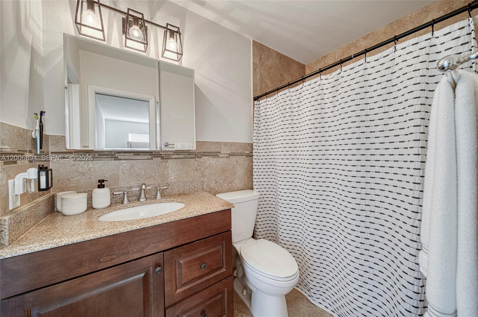 10600 Southwest 80th Court Miami, FL 33156 - Photo 28 of 51 a bathroom with a granite countertop toilet sink and mirror