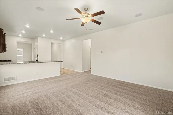 wooden floor in an empty room with a ceiling fan