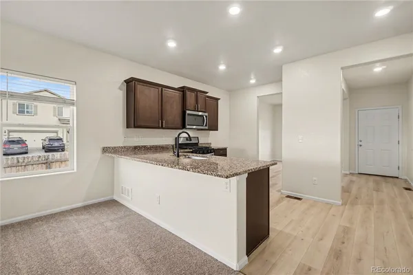 a kitchen with stainless steel appliances granite countertop a sink stove and refrigerator