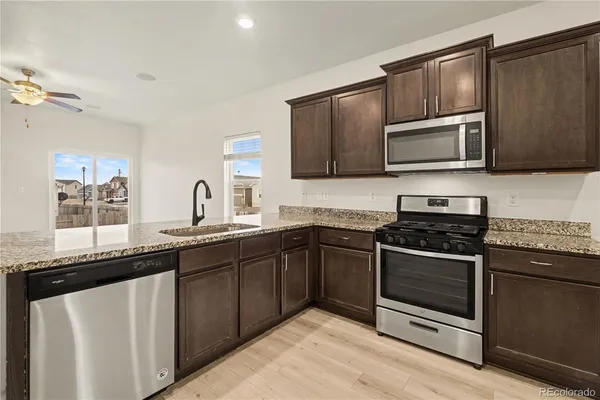 a kitchen with stainless steel appliances granite countertop a stove microwave and sink