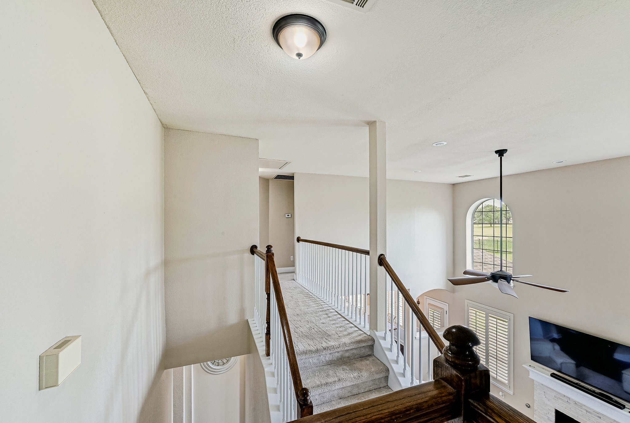 2408 Amen Corner Road Pflugerville, TX 78660 - Photo 33 of 40 Upper level hallway featuring wood handrails, white balusters, and neutral-toned carpeting