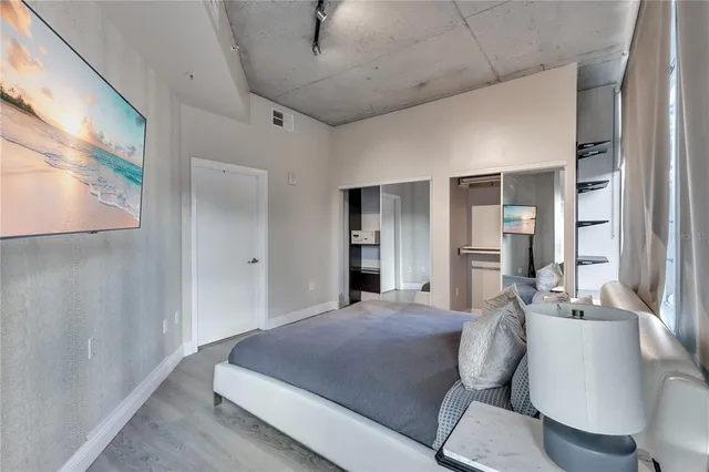 a bedroom with a large bed and a chandelier