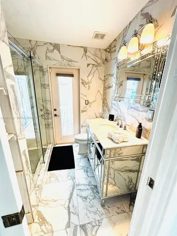 a bathroom with a sink and mirror with bathtub
