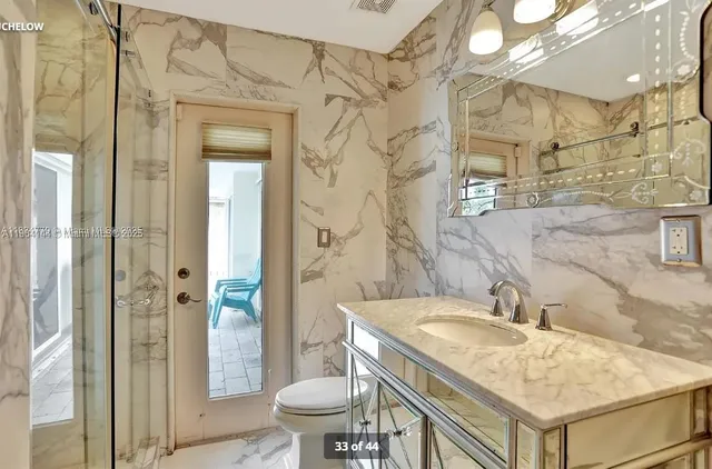 a bathroom with a granite countertop sink a toilet and shower