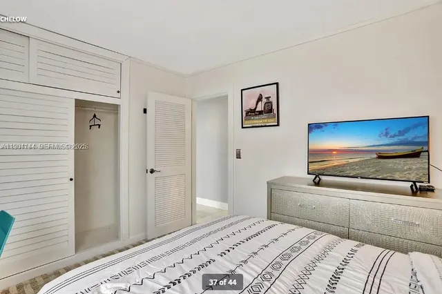 a bedroom with a bed and a flat screen tv