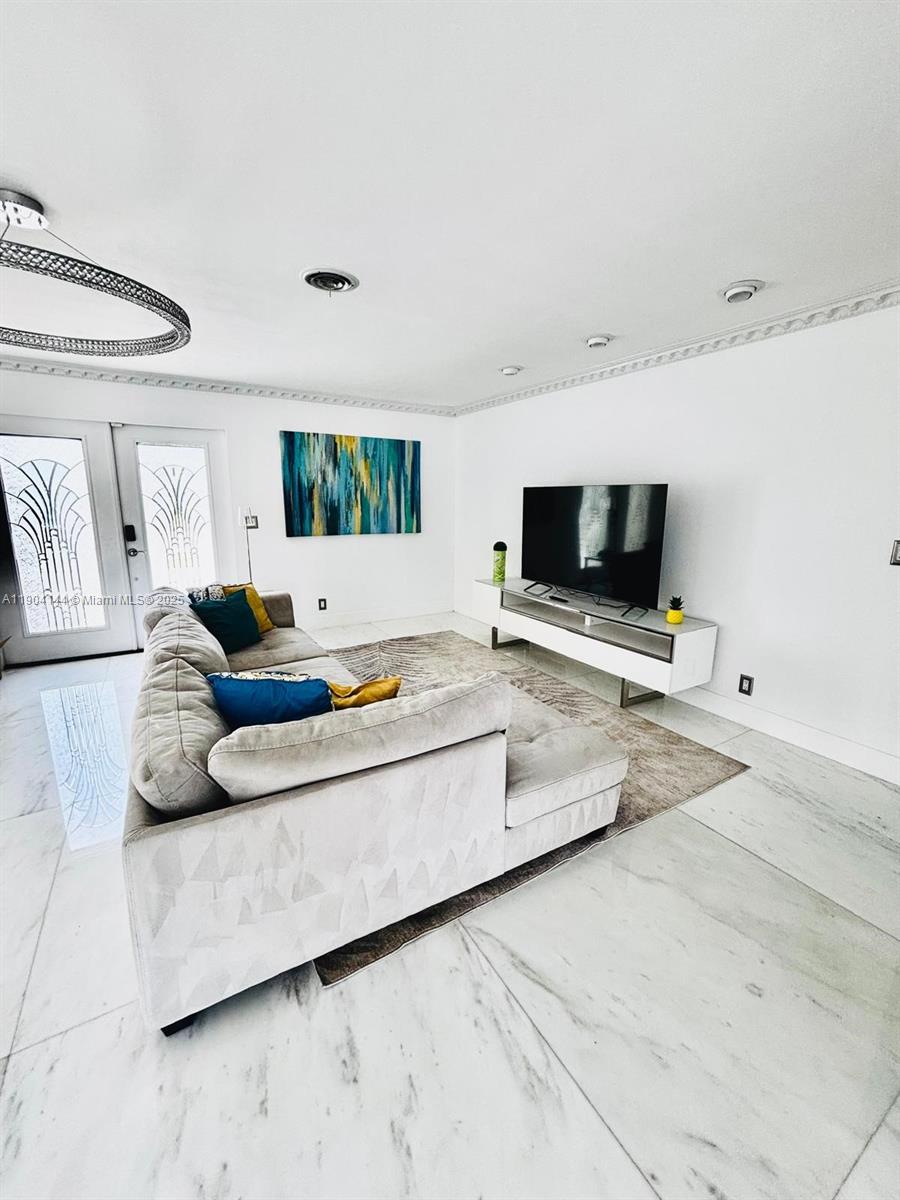 2321 Southeast 15th Street, Unit 2321 Pompano Beach, FL 33062 - Photo 20 of 26 a living room with furniture and a flat screen tv