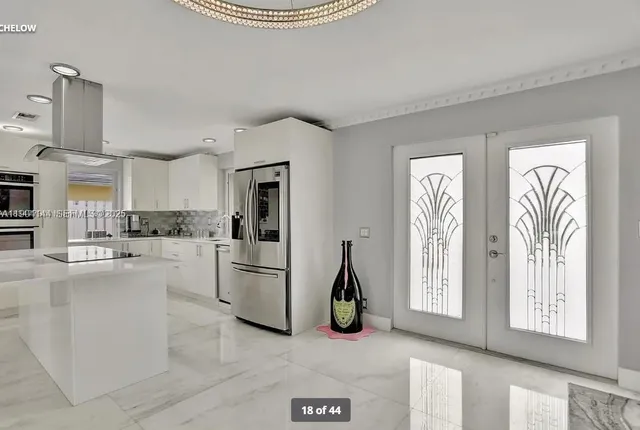 a view of a kitchen with refrigerator and windows