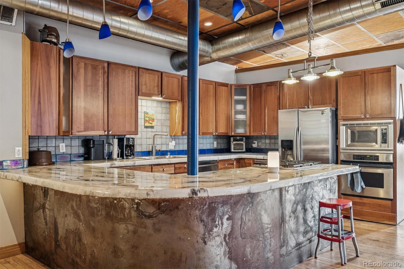 760 Santa Fe Drive, Unit 2 Denver, CO 80204 - Photo 11 of 33 a kitchen with stainless steel appliances kitchen island granite countertop a sink and cabinets