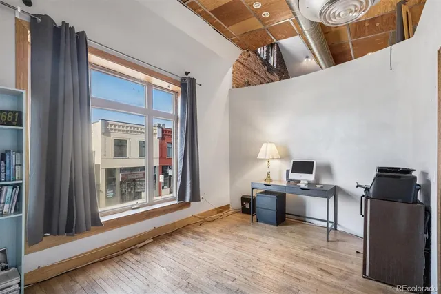 a view of a workspace with furniture and a window
