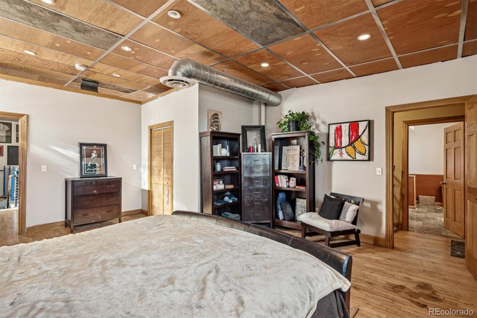 760 Santa Fe Drive, Unit 2 Denver, CO 80204 - Photo 26 of 33 a spacious bedroom with a bed and a desk