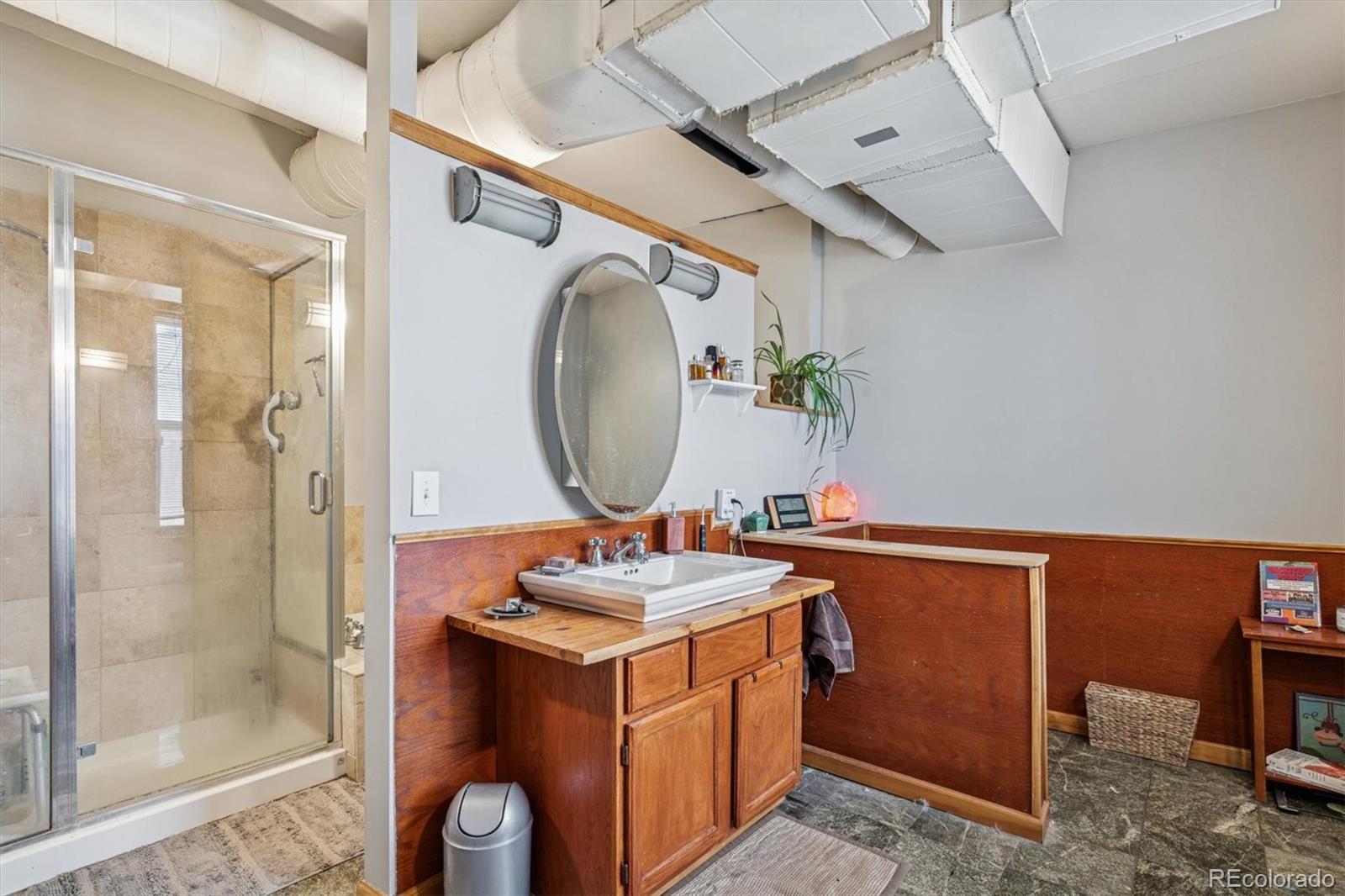 760 Santa Fe Drive, Unit 2 Denver, CO 80204 - Photo 28 of 33 a bathroom with a sink a mirror and a shower