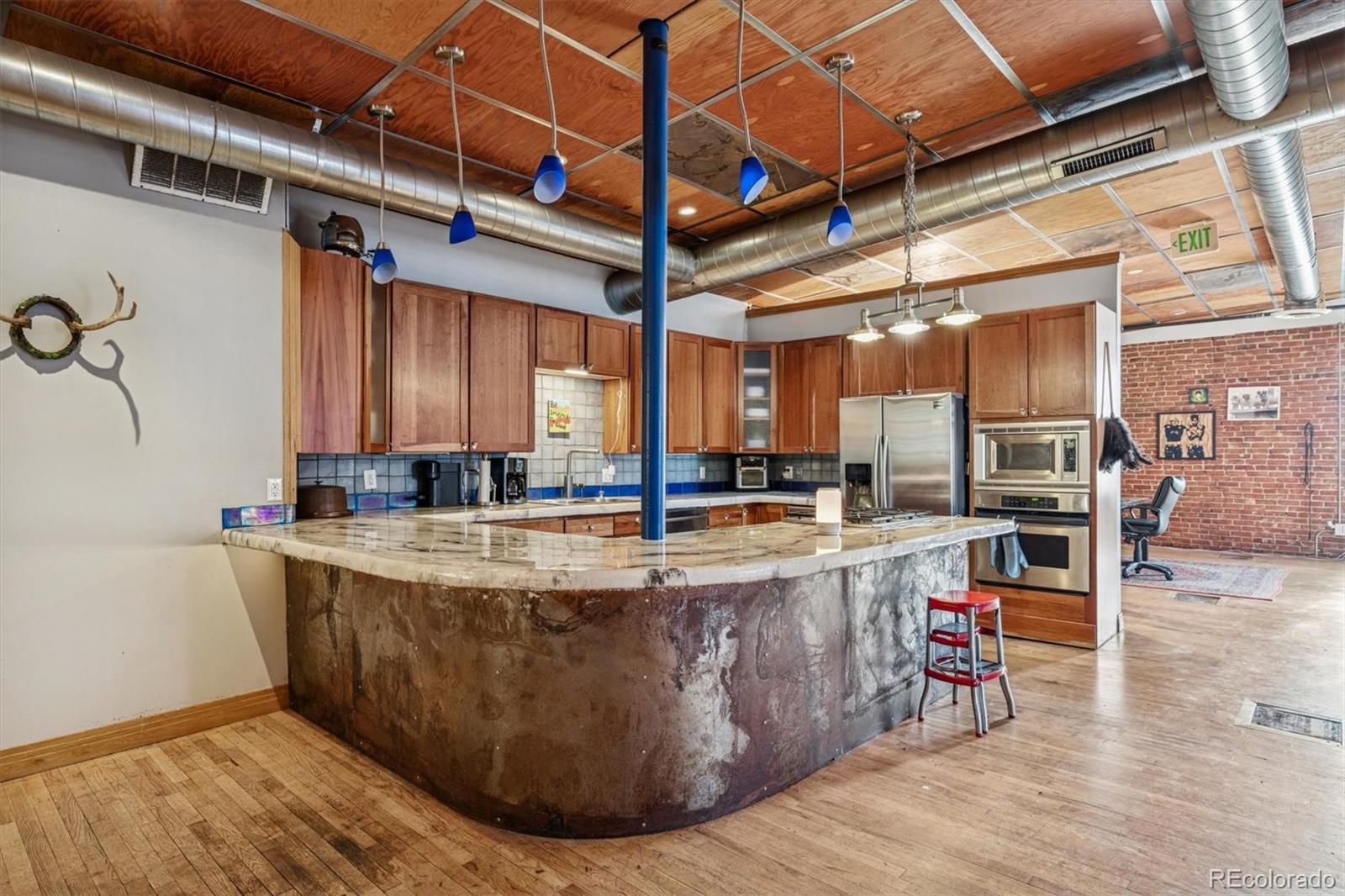 760 Santa Fe Drive, Unit 2 Denver, CO 80204 - Photo 9 of 33 a view of a kitchen with kitchen island a counter top space a sink and wooden floor