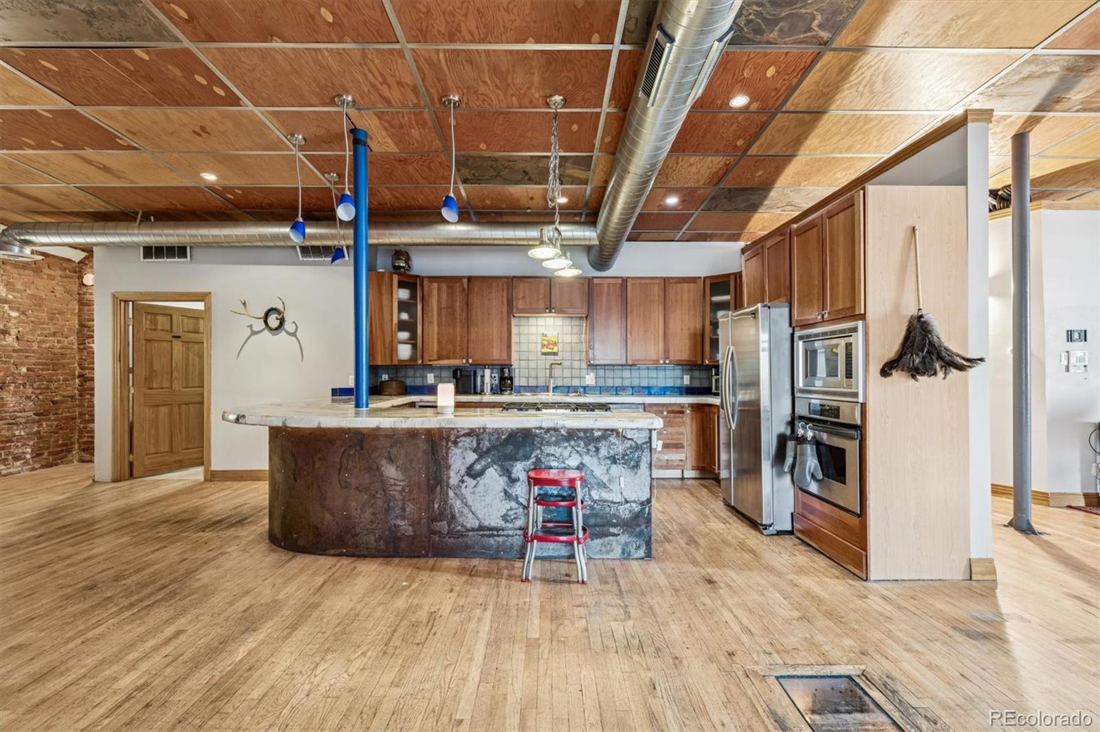 760 Santa Fe Drive, Unit 2 Denver, CO 80204 - Photo 10 of 33 a living room with stainless steel appliances kitchen island granite countertop a table chairs and a refrigerator