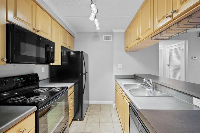 a living room with stainless steel appliances a fireplace and a flat screen tv