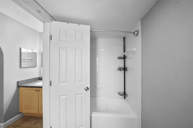 an empty room with a chandelier fan and windows